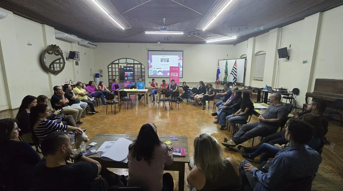 Pessoas em uma roda de cadeiras fazendo uma reunião.